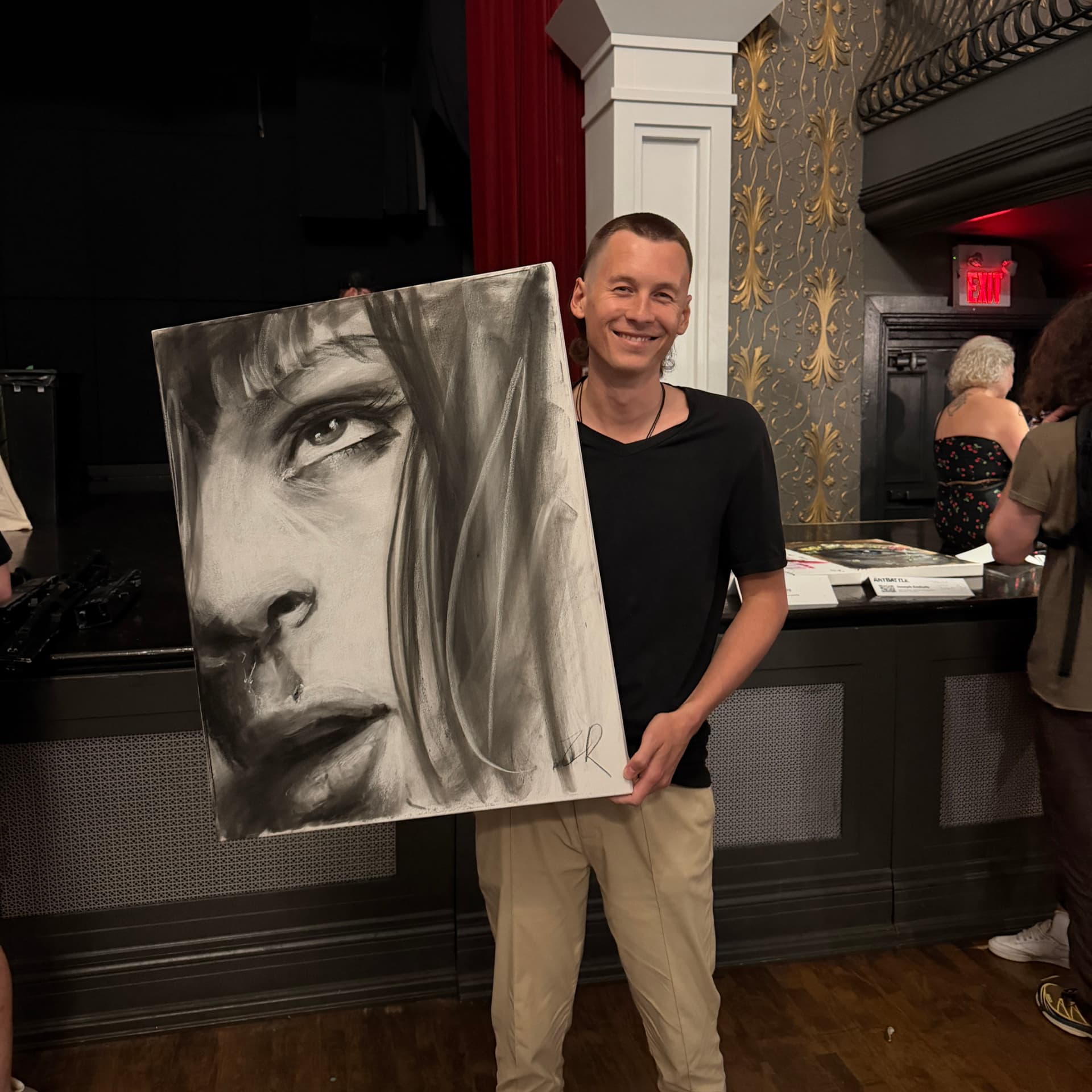 Ruslan holding one of his paintings at a premiere