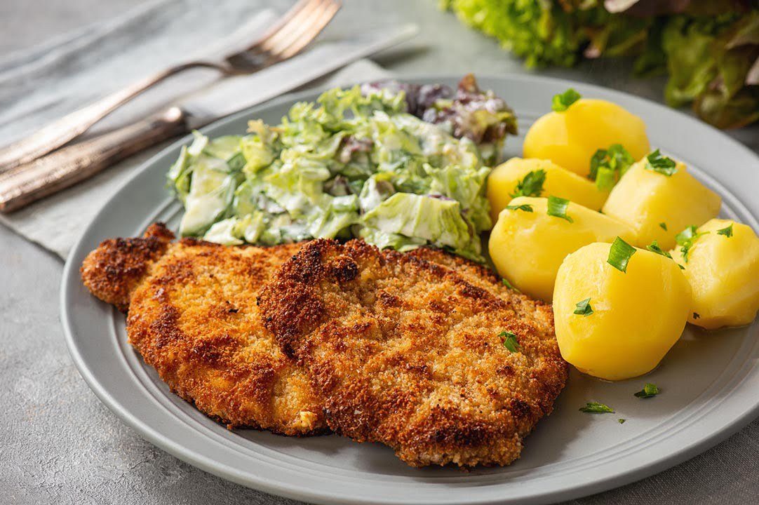 A schnitzel lunch with potatoes and salad